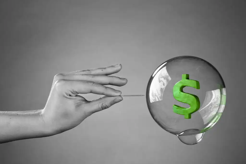 A hand holding a needle to a bubble with a green dollar sign.