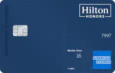 A blue Hilton Honors American Express credit card featuring a chip on the left, the Hilton Honors logo at the top right, and the American Express logo at the bottom right.