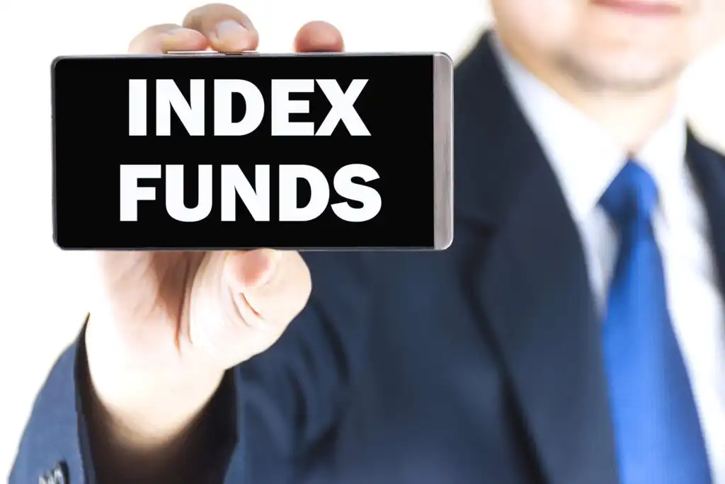 A person in a suit and blue tie is holding up a sign or smartphone displaying the words INDEX FUNDS in large, bold white letters on a black background.