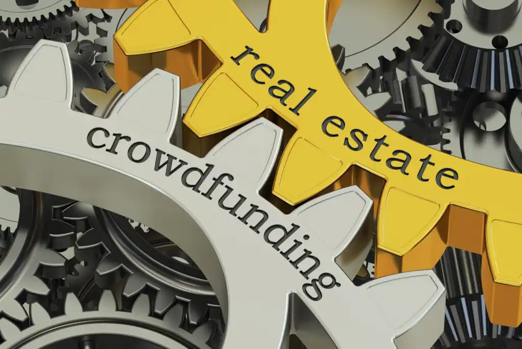 Two interlocking gears, one gold and labeled real estate and one silver and labeled crowdfunding, surrounded by other gears, symbolizing the connection between real estate and crowdfunding concepts.