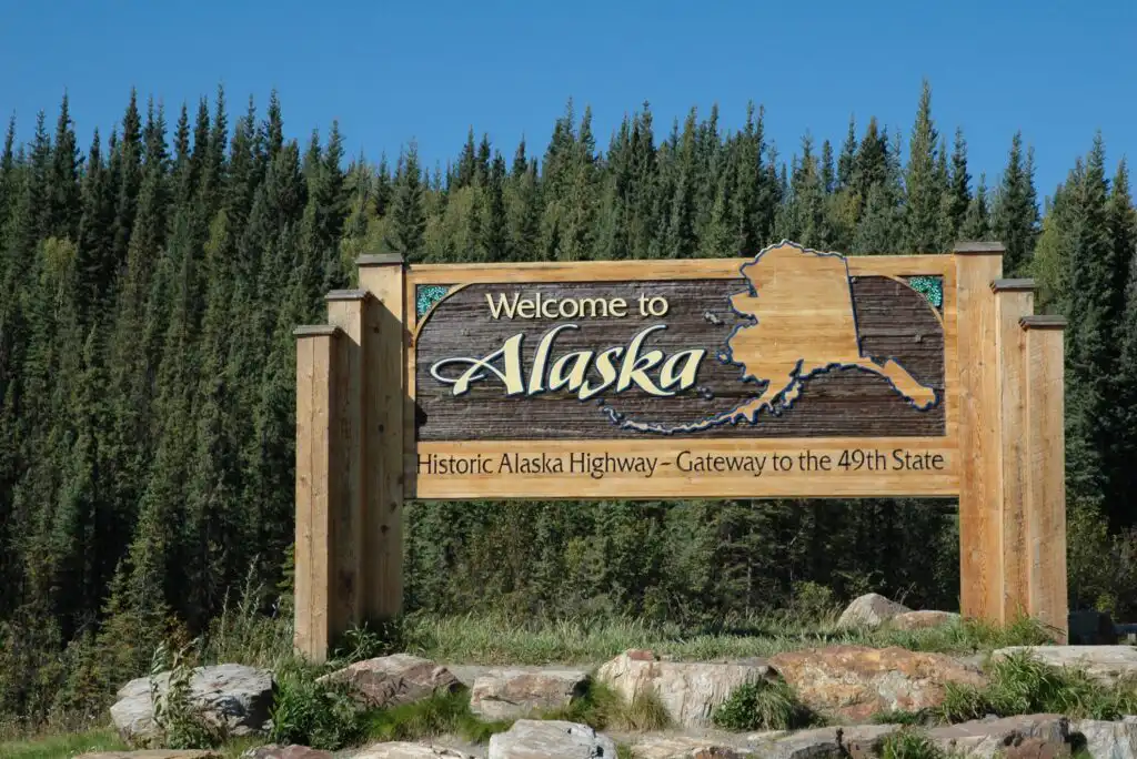 A sign in front of trees.