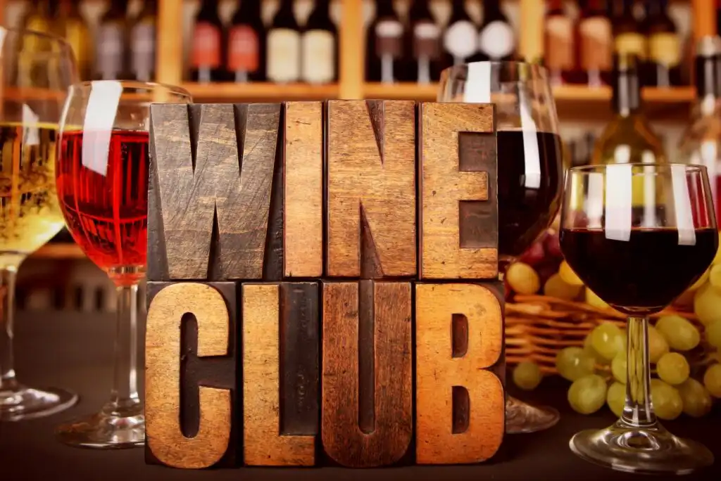 A group of glasses of wine next to a wooden block.
