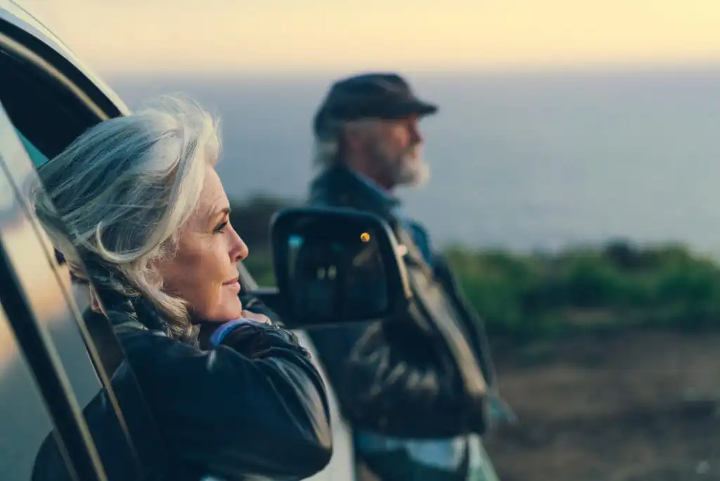 A man and woman looking out of a car window.